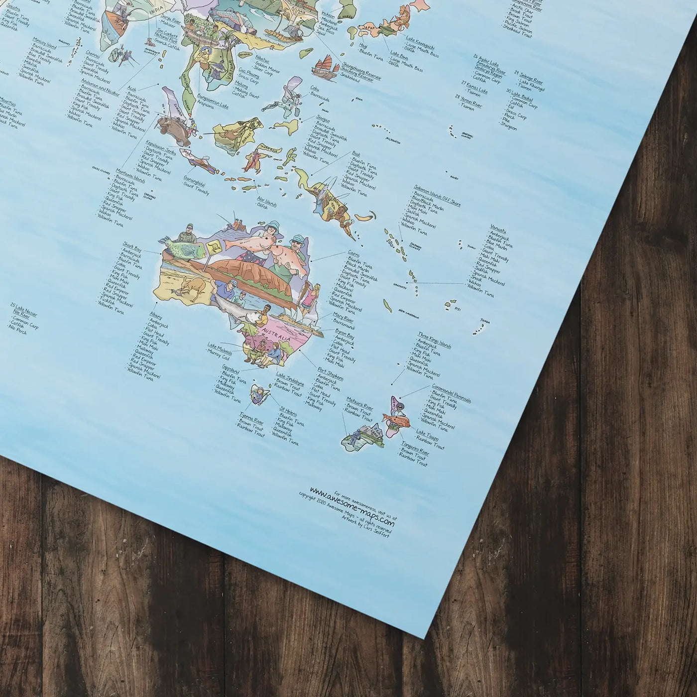 Bottom right corner of the Fishing Map poster of the world lying flat on a table