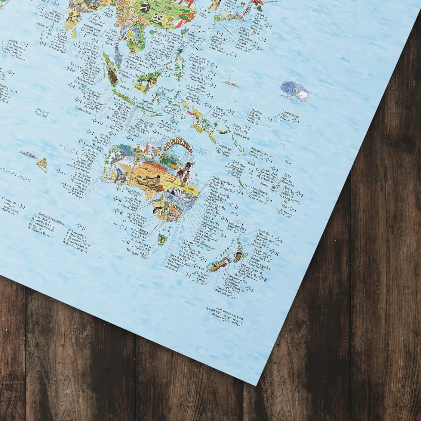 Bottom right corner of the Surftrip Map poster of the world lying flat on a table