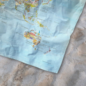 Bottom right corner of the Running Map towel of the world lying on the sand