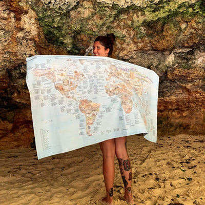 Someone holding the Climbing Map towel at the beach