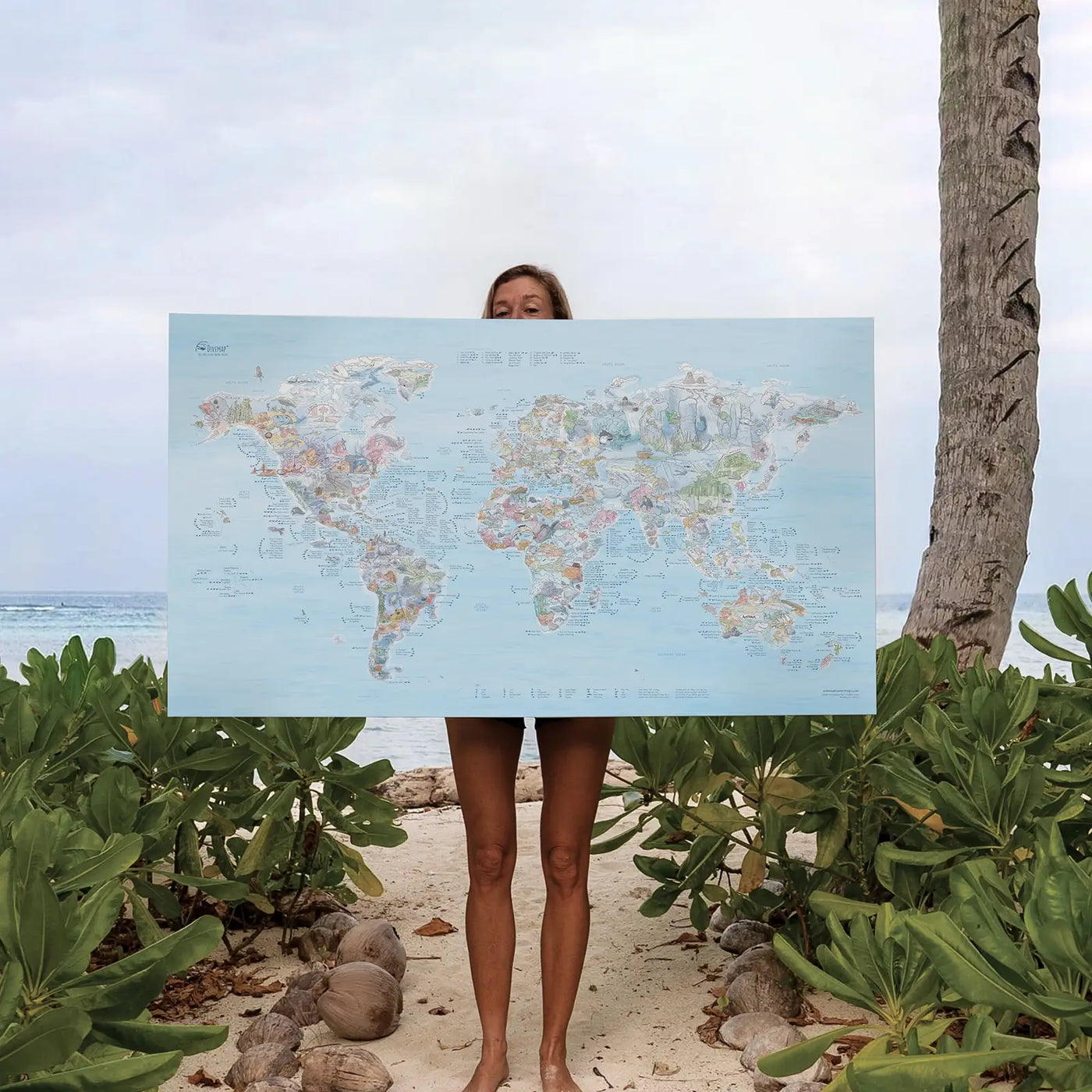 Someone holding the Dive Map canvas at the beach