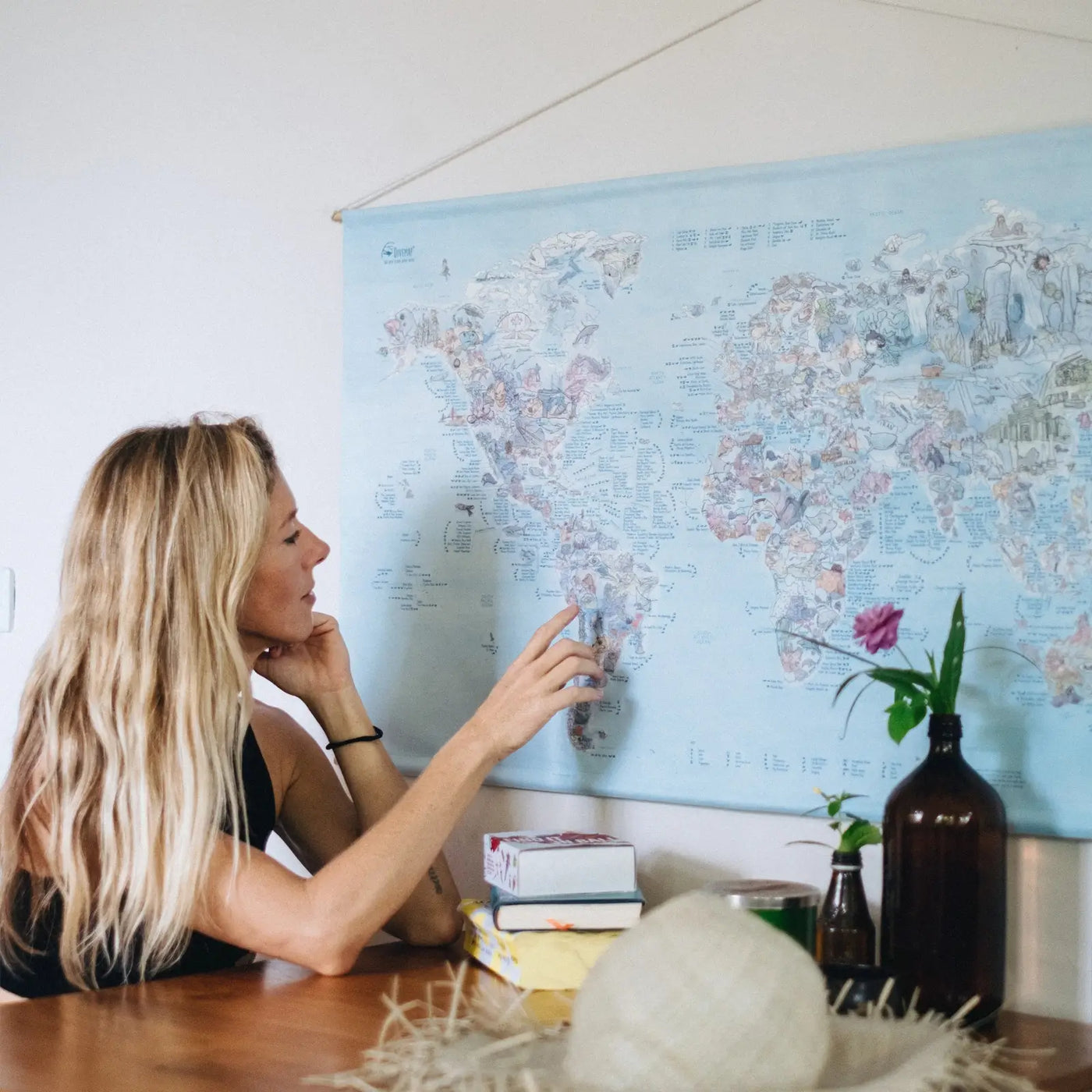 Someone sitting in front of the Dive Map roll down canvas hanging on the wall