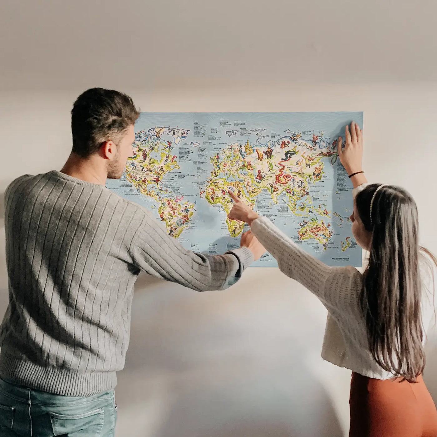 A couple looking at the Golf Map poster hanging on the wall