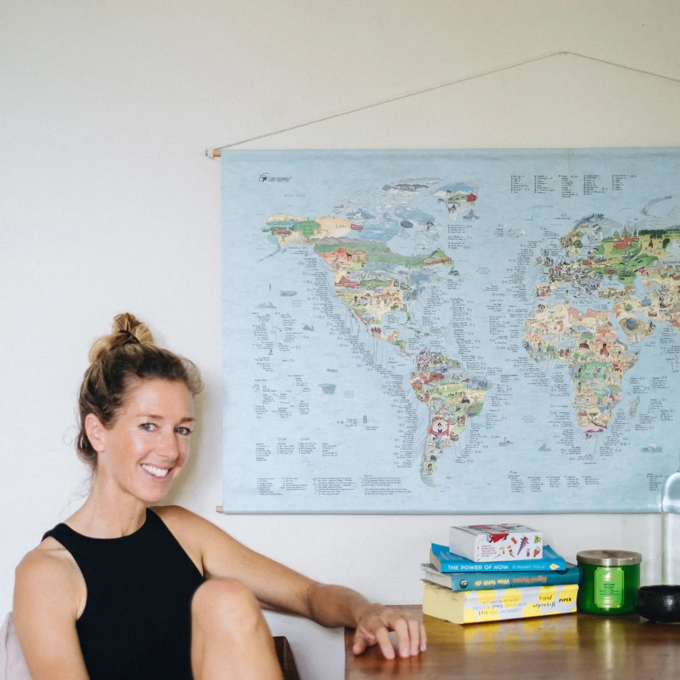 Someone sitting in front of the Surftrip Map roll down canvas hanging on the wall