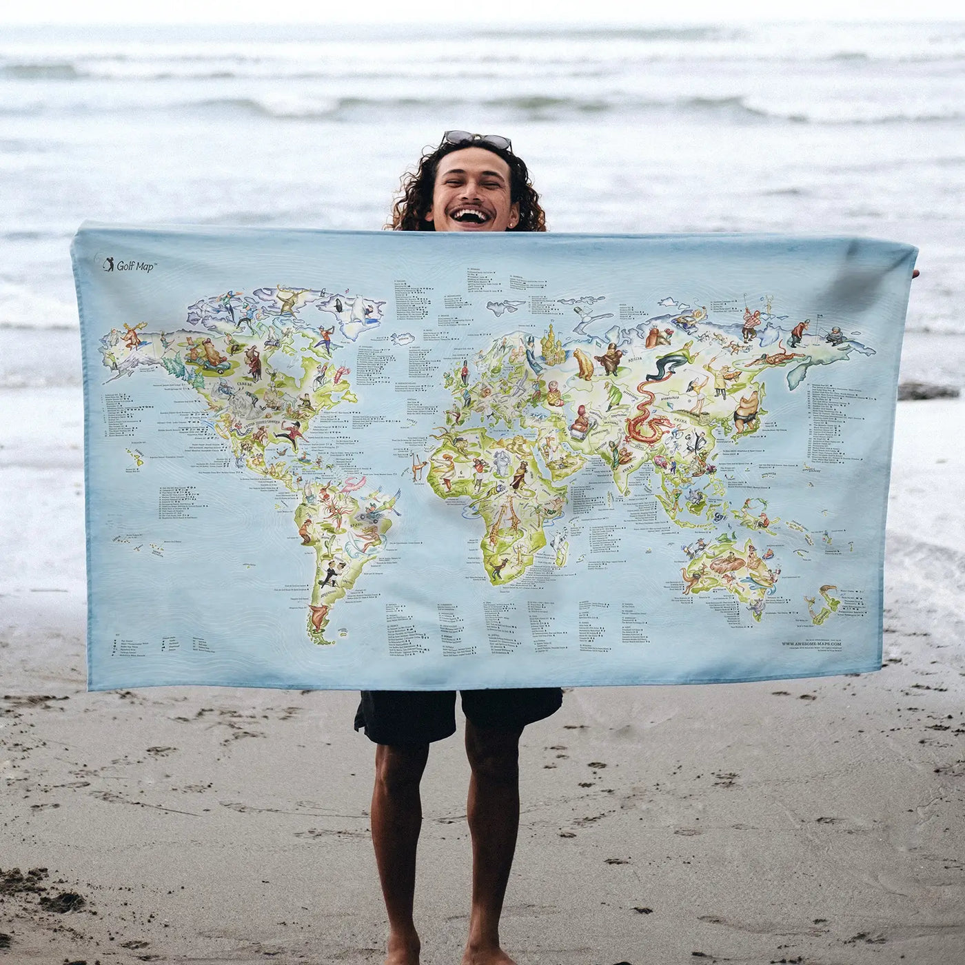 Someone holding the Golf Map towel at the beach